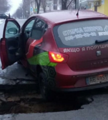 Утворилася глибока яма: у Дніпрі під автівкою служби таксі провалився асфальт