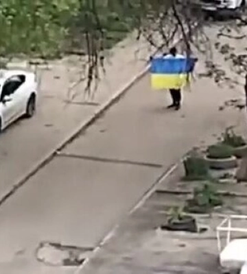 Невідомий чоловік вийшов з прапором України у двір житлової багатоповерхівки окупованого Маріуполя. ВIДЕО