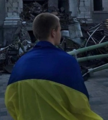 Юнак з прапором України вийшов на площу біля розбомбленого маріупольського Драмтеатру. ФОТО