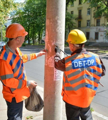 Комунальники Дніпра очищають вулиці від незаконно розміщених оголошень