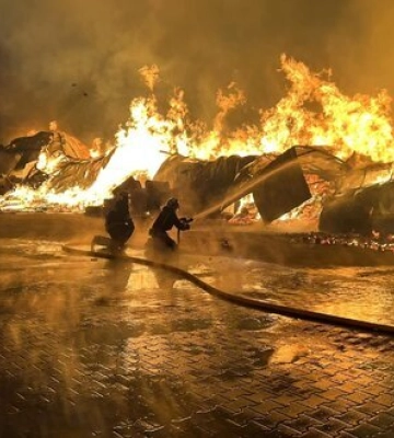 Після ворожої атаки у Подільському районі Києва палає складська будівля