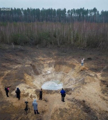 Фото дня: вирва від російської ракети у лісі біля Бучі