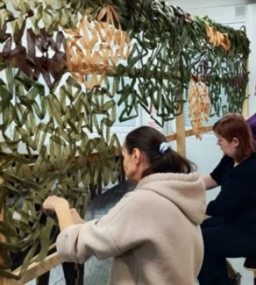 У модульному містечку Львова переселенці плетуть маскувальні сітки для ЗСУ