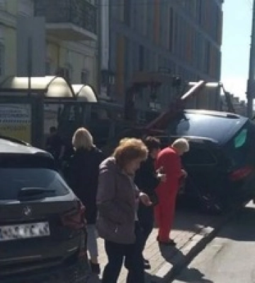 В центре Киева с эвакуатора упал автомобиль нарушителя ПДД. Подробности и фото
