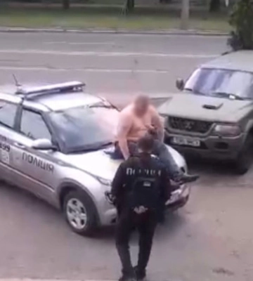 В Киеве мужчина залез на капот авто полиции и ударил правоохранителя: фото и видео