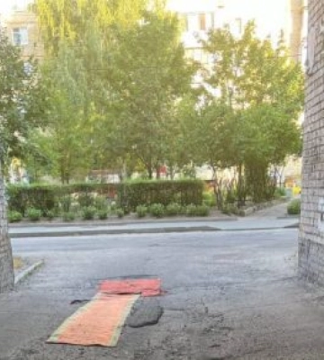 У Дніпрі мешканці житломасиву Перемога застеляють ями на дорогах килимами