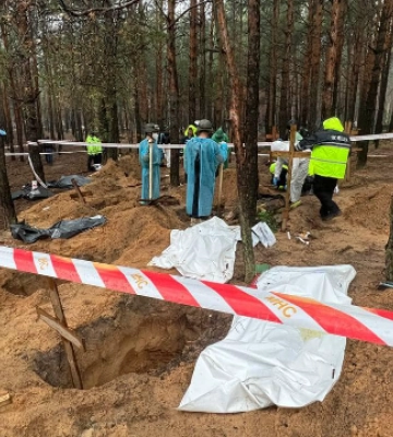 Без кінцівок та геніталій: в Ізюмі ексгумувала 447 тіл на місці масового поховання