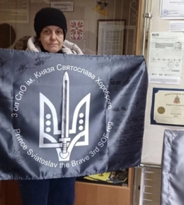 Мама загиблого воїна передала ковельському музею прапор з підписами побратимів, яких він врятував
