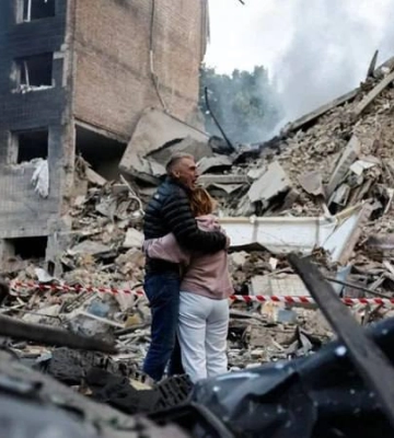 Ці фото облетіли світ: у Києві подружжя стоїть перед будинком, де залишається їхня дитина