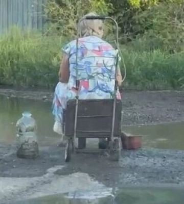 Донбас без води: літня жінка черпає її з калюжі. ВIДЕО