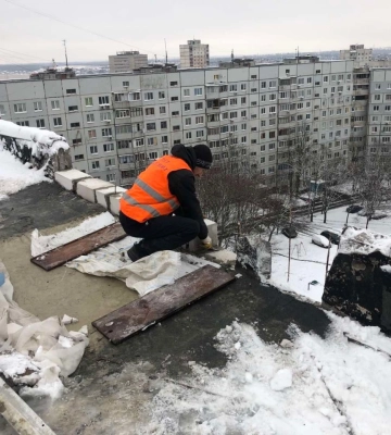 В Харькове строители восстанавливают заснеженные крыши после обстрелов 