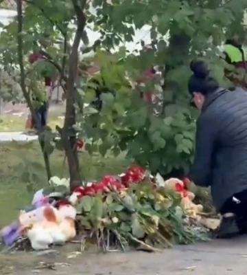 У Києві люди несуть квіти та іграшки до зруйнованої ударом РФ багатоповерхівки (відео)