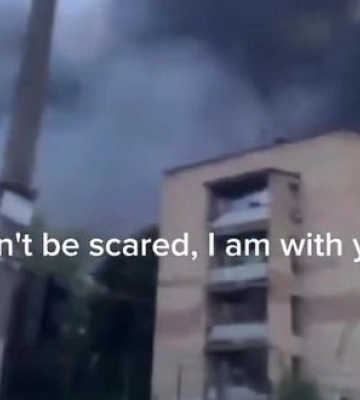Маленький хлопчик на охопленій димом і полум’ям вулиці Вишневого під звуки вибухів заспокоює свою маму: "Не бійся. Я з тобою. Не бійся". ВIДЕО